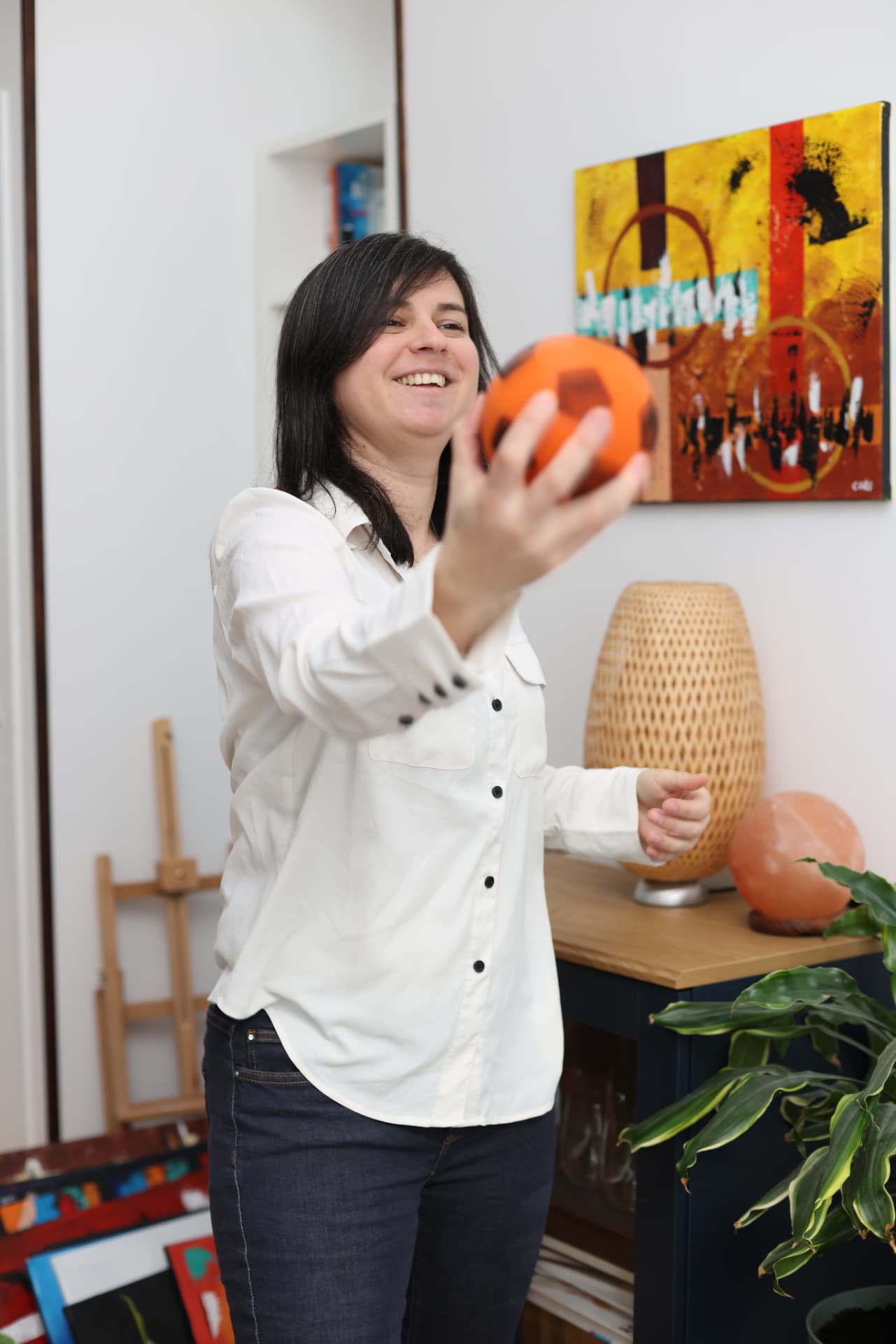 Claire Chassin souriante, entourée de ses toiles